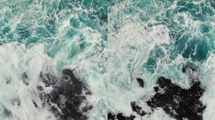 带着白色泡沫的海浪拍打着岩石。从空中俯瞰暴风雨的海浪。海或海浪飞溅，竖屏