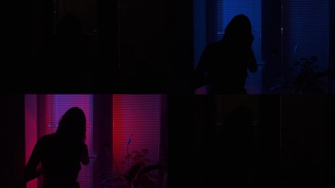 一个吓坏了的女人透过百叶窗向窗外看。街上警笛的红色和蓝色警灯闪烁着