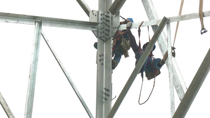 架设电力杆塔的高空作业工人