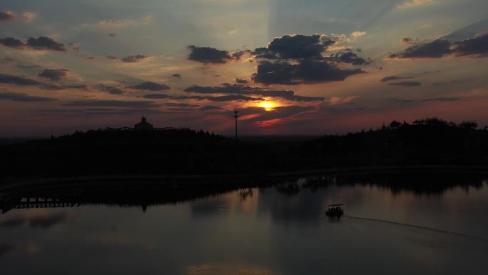 夕阳下的双山子公园湖面上划船