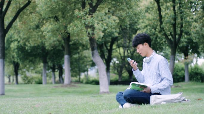 文艺男生草地上学习看书英语
