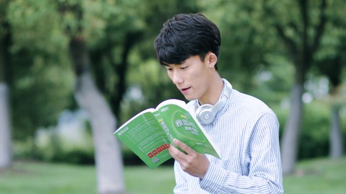 文艺男生草地上学习看书英语
