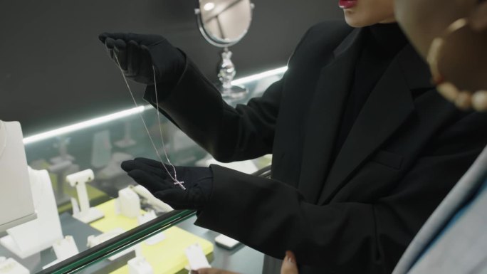 销售人员向黑人顾客展示带十字的白金链