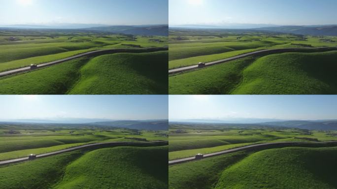 一辆汽车行驶在横穿过草原的公路上