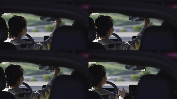 女孩坐在车中调整后视镜并准备驾驶
