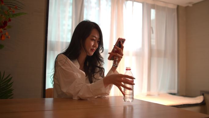 年轻女性在家里玩手机
