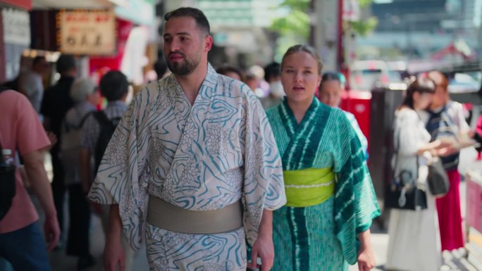 访问日本的年轻夫妇穿着日本传统服装和服或浴衣在东京街头散步