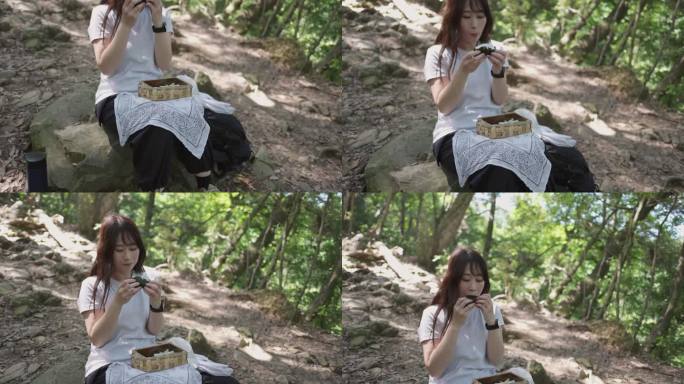 女徒步者坐在山间小道上吃午饭——仰头