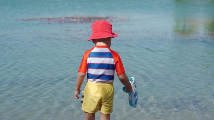 夏日里，穿着防晒服的小孩在湖边玩耍。