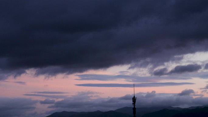 夏日夕阳信号塔上空黑压压乌云延时摄影