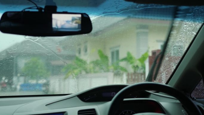 雨季大雨滂沱，雨点打在汽车挡风玻璃上