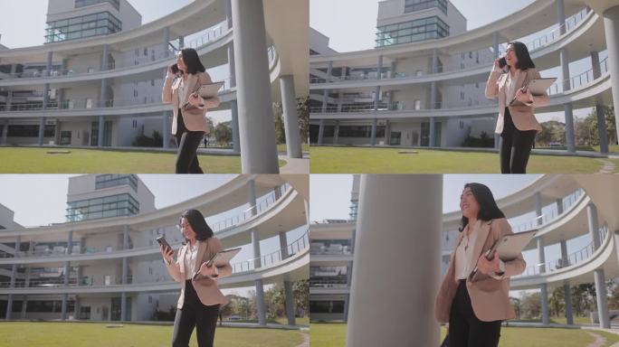 一位女士走在办公楼里打电话。她正在用手机和同事通话。