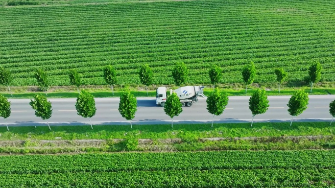 4K平原乡村公路上行驶的水泥搅拌车