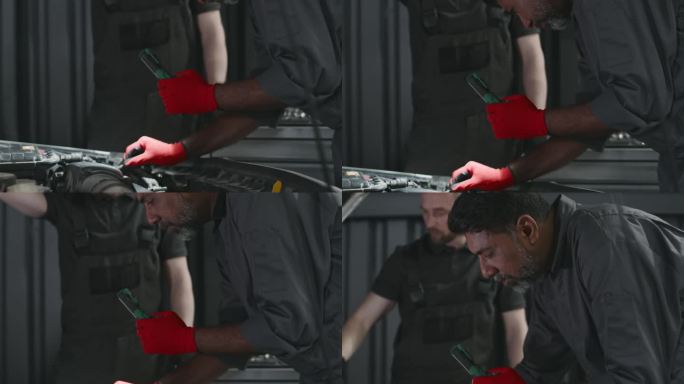 亚洲男机械师用火炬检查汽车发动机电压