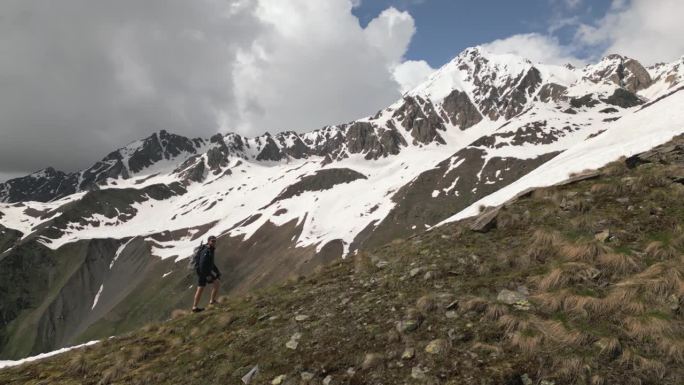 登山运动员背着背包爬雪山。空中高空探险，挑战攀登，风景优美。爬山，在遥远的雪原里探险。无人机拍摄的