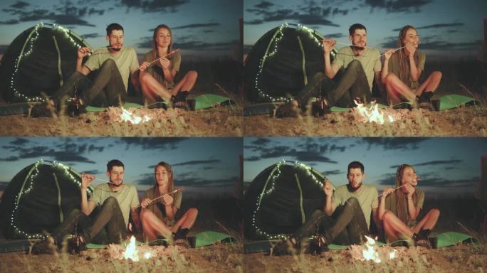 体验一个浪漫的晚上露营的篝火在黄昏，被宁静的荒野包围。在美丽的星空下享受一个舒适的夜晚