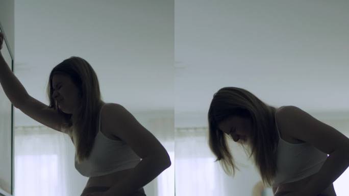 孕妇临产的剪影。她疼了，摸了摸肚子。