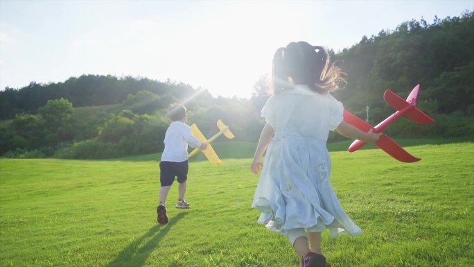 小孩拿着飞机模型草地奔跑追逐欢乐童年时光