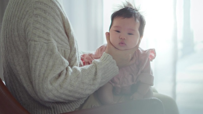 亚洲妈妈妈妈抱着她的孩子做一个打嗝在家里母乳喂养后，母性，照顾