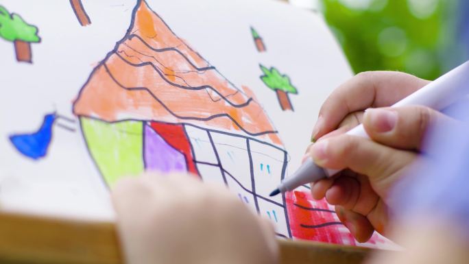 幼儿园孩子拿画笔绘画大手拉小手温馨开心