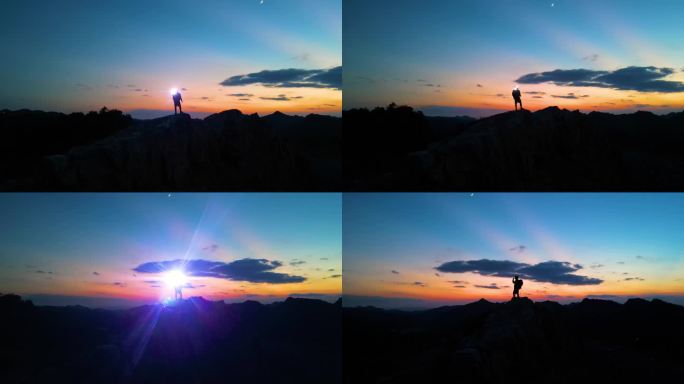 探险家黑夜登顶山顶打着手电筒照亮前行的路