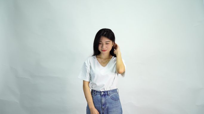 美女站在白色背景下慢慢抬头看向镜头微笑