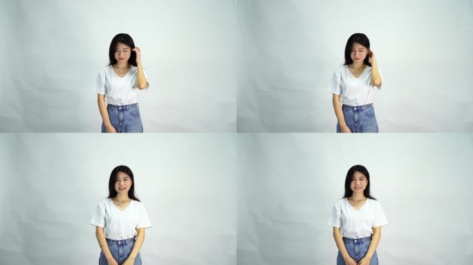 美女站在白色背景下慢慢抬头看向镜头微笑