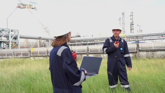 工程师在炼油厂和化工厂工作。高级工程师，穿着安全夹克和个人防护用品，从事石油化工产品进出口工作。原油