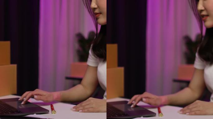 一名年轻女子开了一家小型网店，她正在检查产品和包裹的箱子，准备送货。女人因销售成功而欣喜。