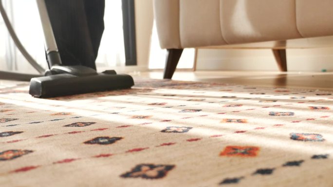 女人用吸尘器清洁地毯，