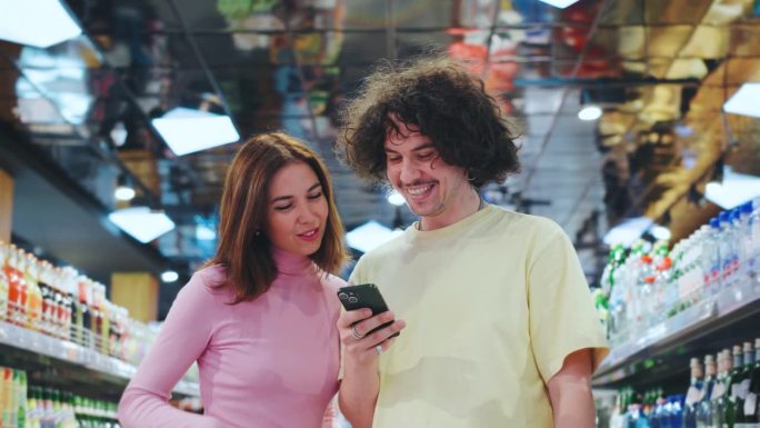 一对快乐的夫妇在一家色彩缤纷的杂货店里愉快地一起购物，一边浏览摆满各种食品的充满活力的货架，一边享受