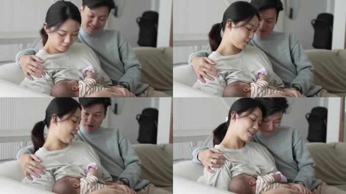 亚洲华人年轻父母在家哺乳女婴