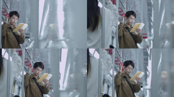 年轻男子在地铁上看书
