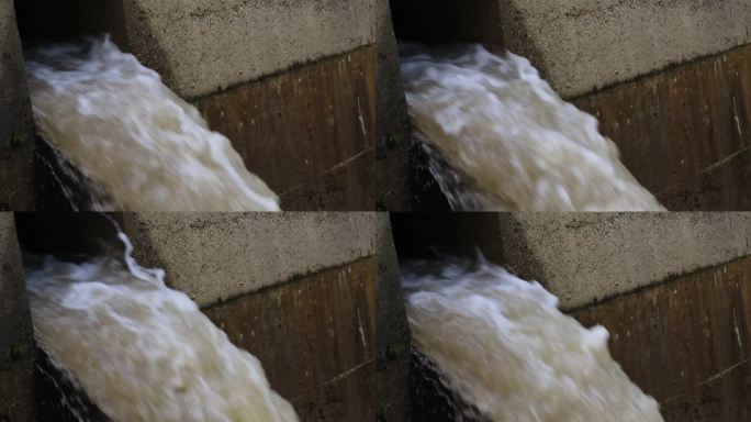 棕色的泥流从大坝吹出来