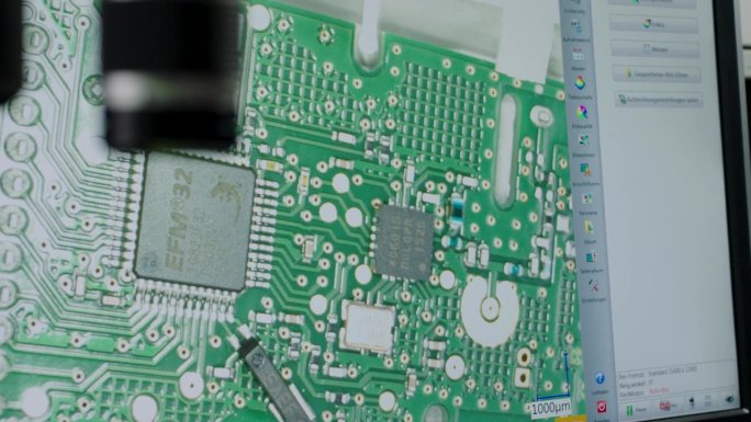 技师在显微镜下检查电路板