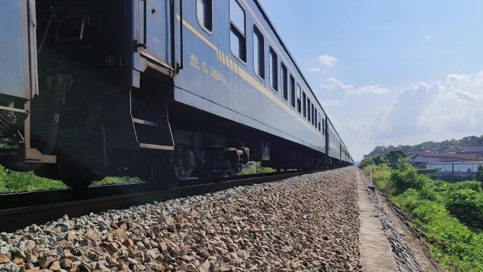 阳光照火车上列车开过普速绿皮火车行驶轨道