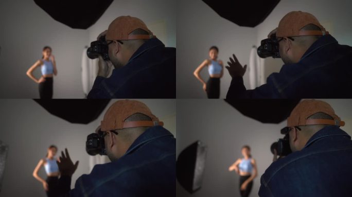 专业男摄影师使用数码相机和闪光灯在白色背景的摄影棚内拍摄女模特。摄影的概念。