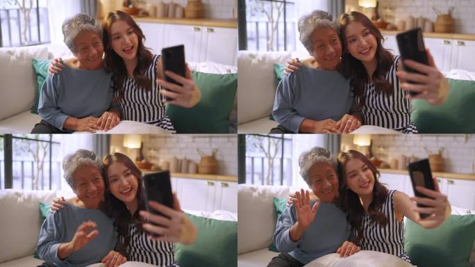亚洲健康生活方式家庭理念微笑的老妇奶奶和成年女儿在家里的客厅沙发沙发上一起视频通话