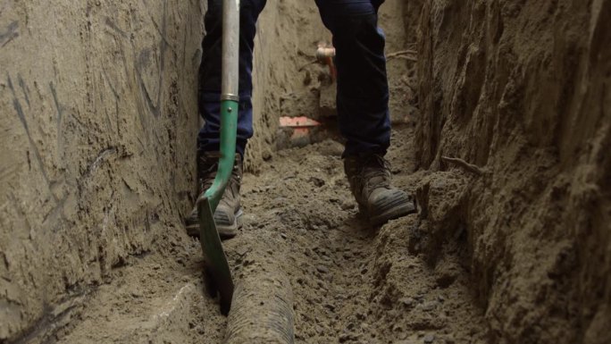 建筑工人在进行地基维修时挖出脱落的瓷砖——近距离