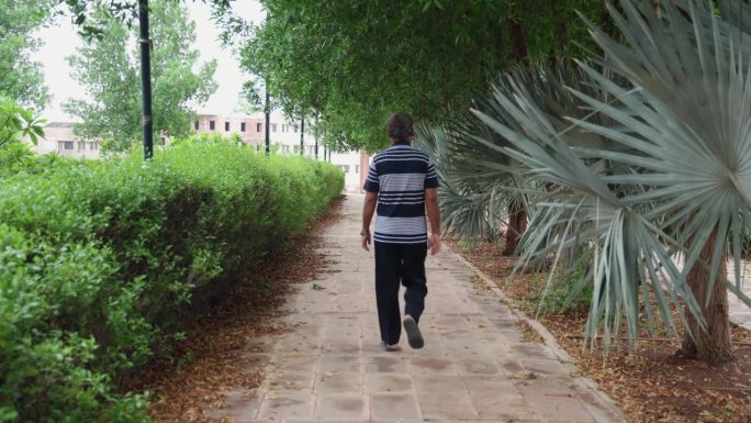 一个孤独的人晚上从不同的角度走在户外公园