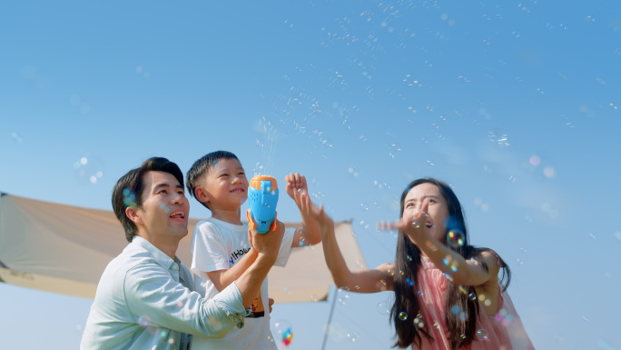 爸爸妈妈带小孩玩泡泡机露营幸福一家玩耍