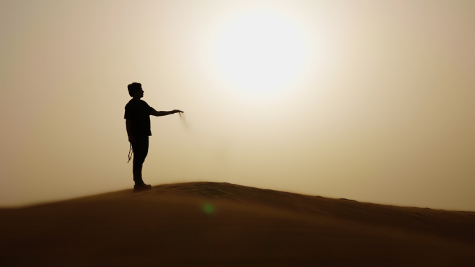 男人沙漠中行走 抓起沙子 沙漠人物剪影