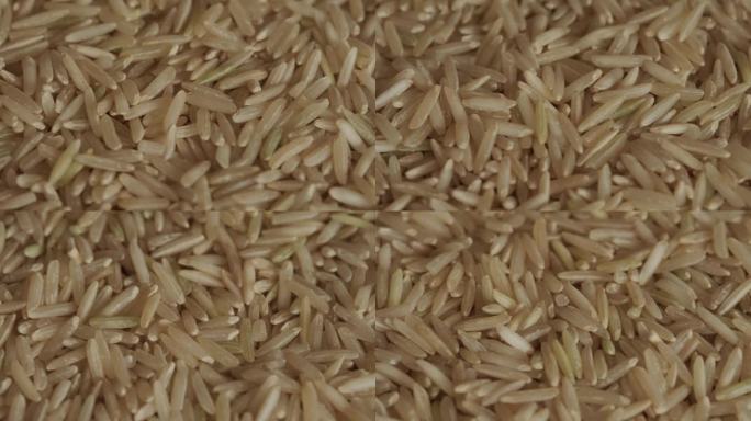 未煮熟的棕色印度香米全麦米背景旋转宏观。亚洲食品。健康饮食理念