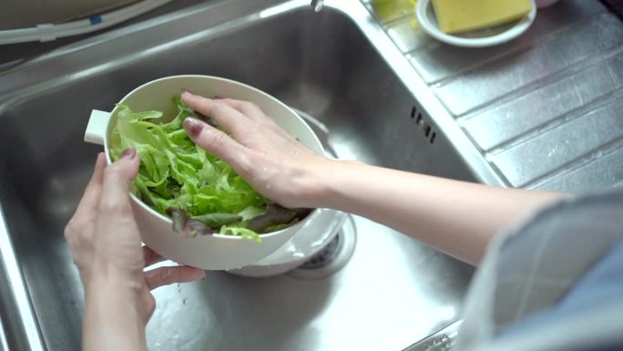 妇女在水里洗蔬菜。