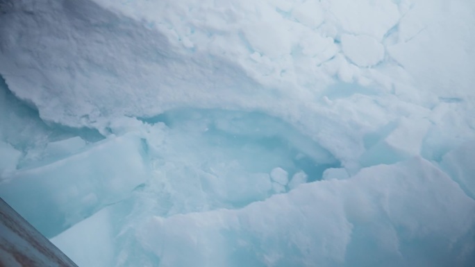 一艘船在北极的北冰洋上航行，在冰封的风景中展示了大自然的美丽和力量