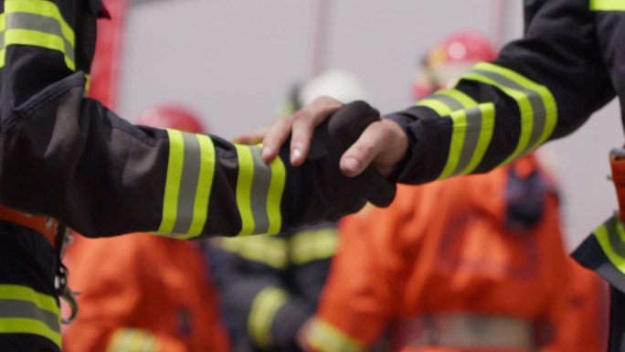 一组消防员在成功的救援行动后聚在一起庆祝，分享他们的喜悦和解脱，展示了这些英雄之间的紧密联系和情谊