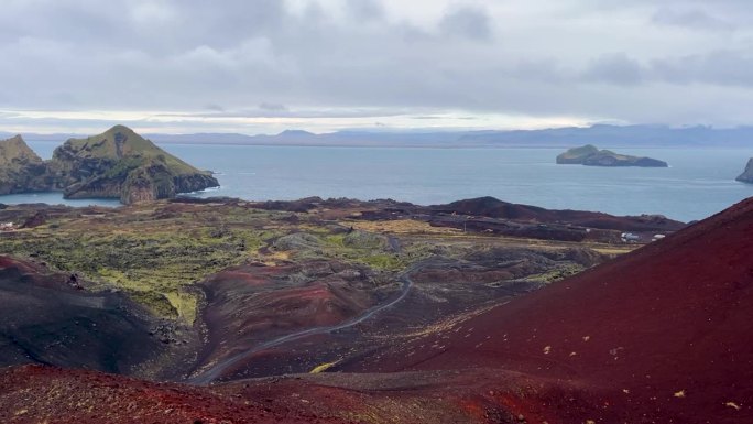 Heimaey岛上色彩斑斓的火山景观，背景是海洋和遥远的岛屿