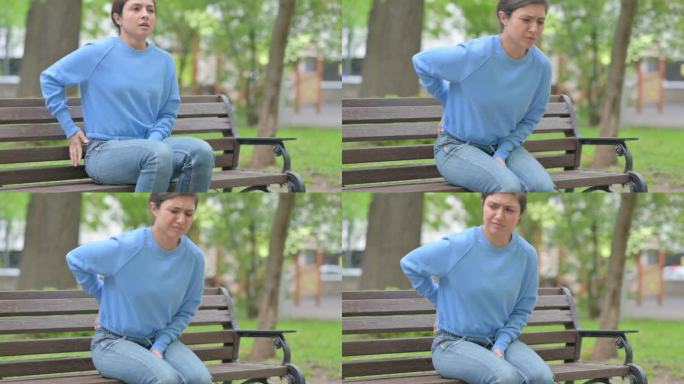 一名印度妇女在室外长凳上站立时背部疼痛