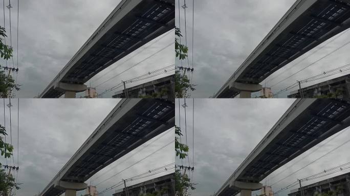 高架轻轨穿过灰色的天空，在自然和城市技术之间形成有趣的对比。