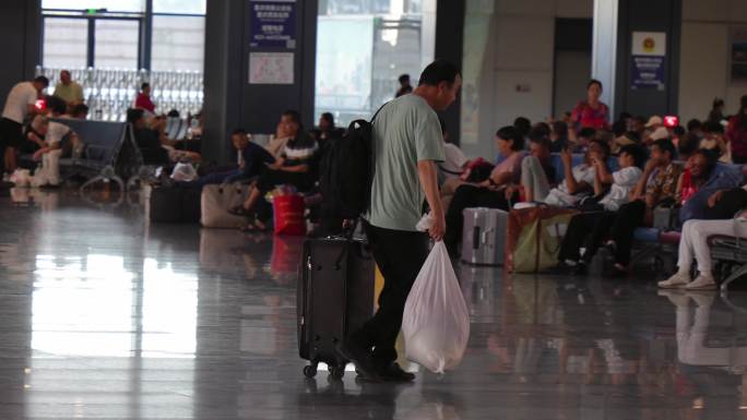 高铁火车站台里陆陆续续赶火车拉行李箱的人